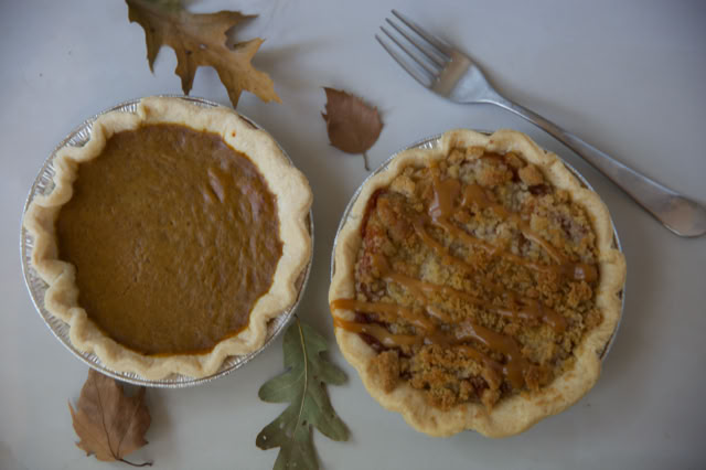 Two Pumpkin Pie Tarts surrounded by autumn leaves, with a fork and knife nearby.