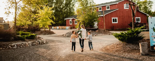 Family walking together on a path with trees.